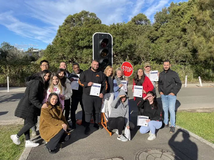 Traffic control students with a stop bat, portable traffic light and their certificates